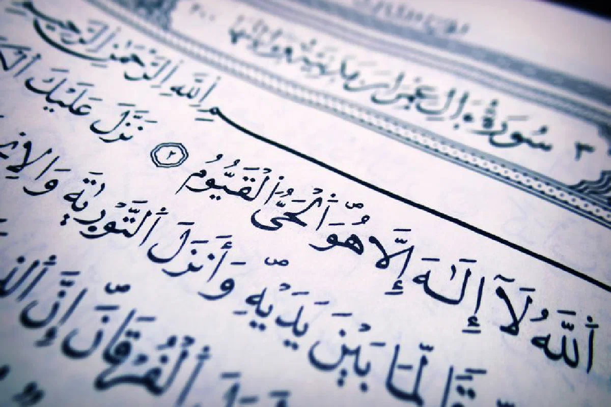 Detailed close-up of Arabic script from a Quran page, highlighting religious text and calligraphy.