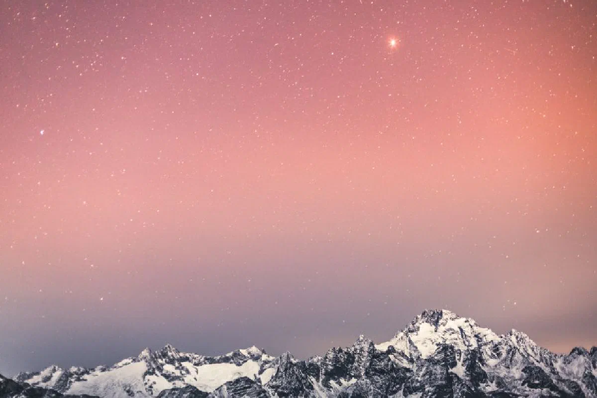 Stunning snowy mountain range beneath a starry sky in Italy, evoking serene beauty and wonder.