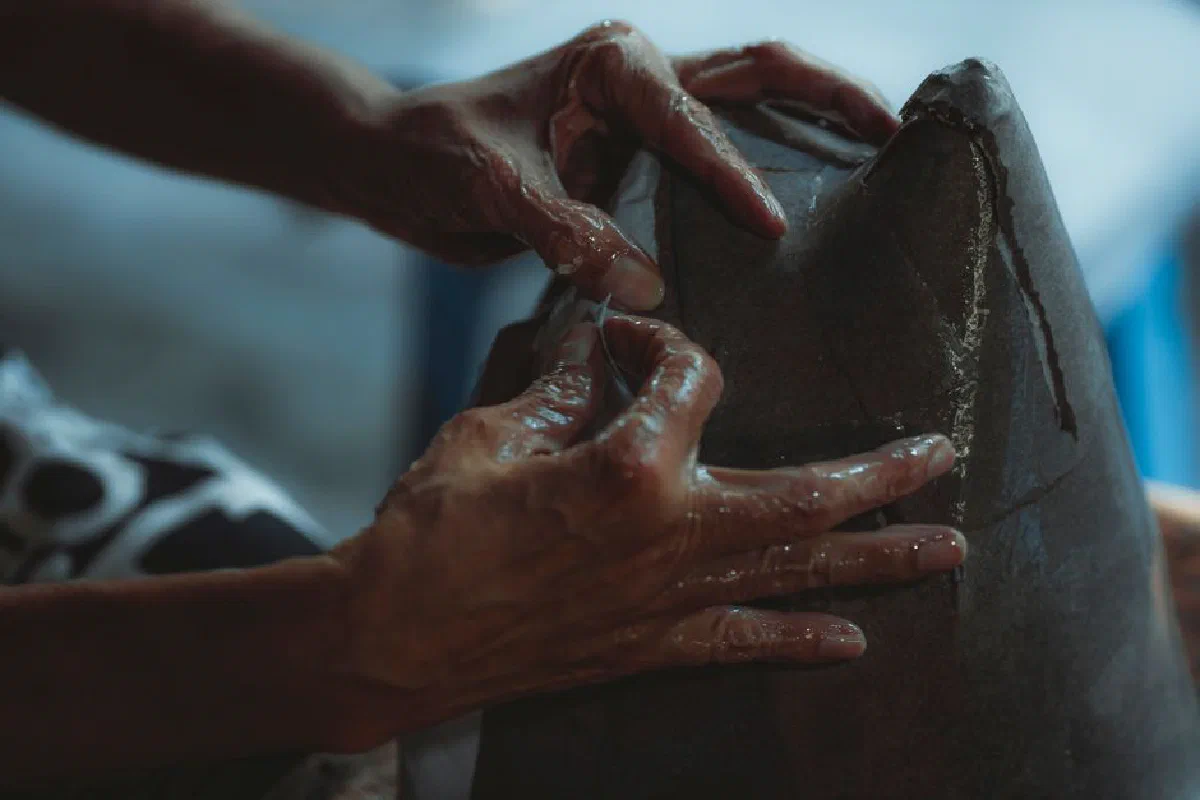 Hands of an artisan skillfully molding clay, showcasing craftsmanship and creativity.