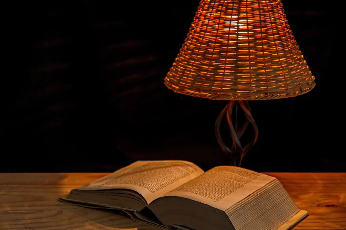 A cozy scene of a book under a woven lamp, perfect for late-night reading in a warm atmosphere.