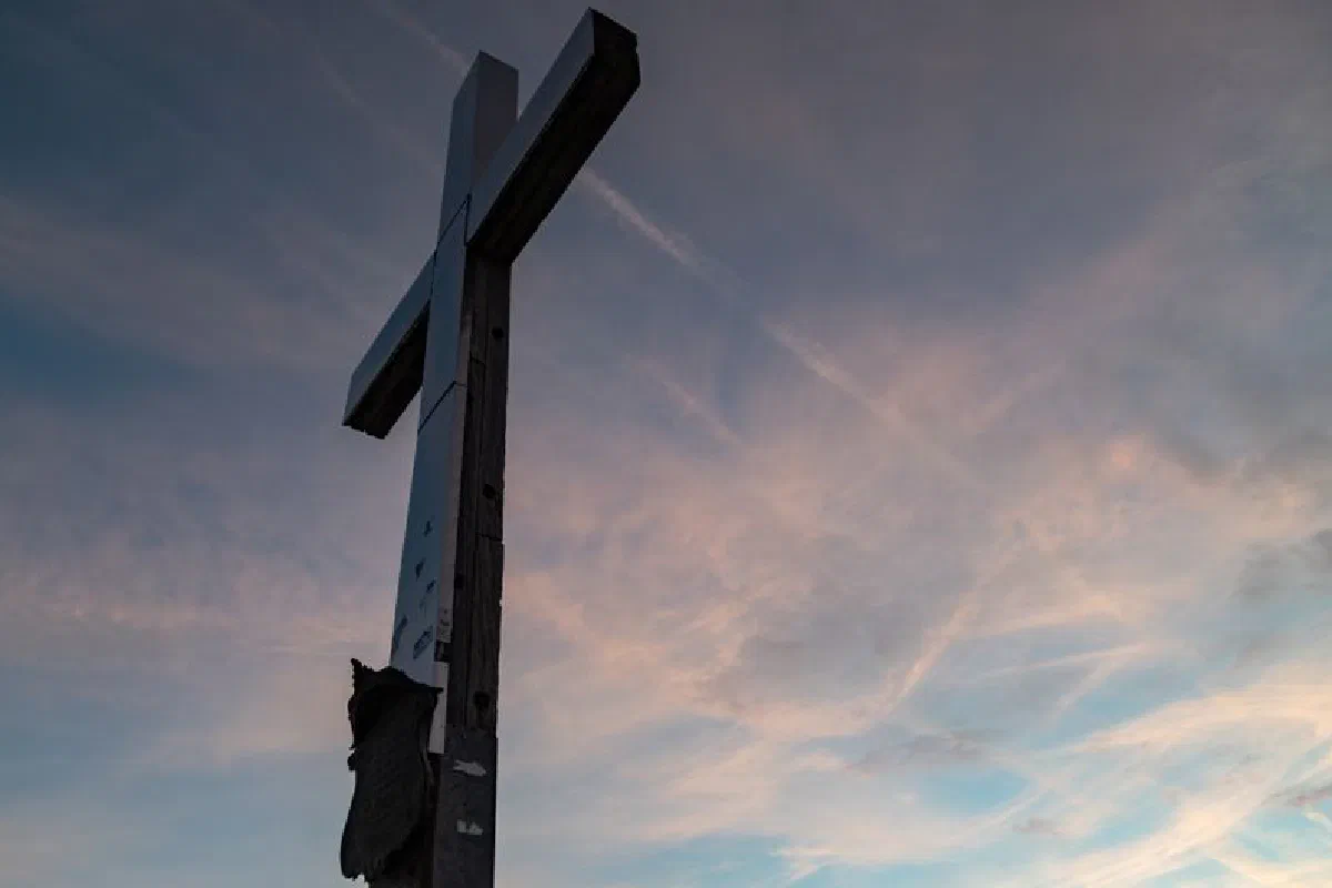 A striking view of a mountain cross at sunrise in Garmisch-Partenkirchen, Germany.