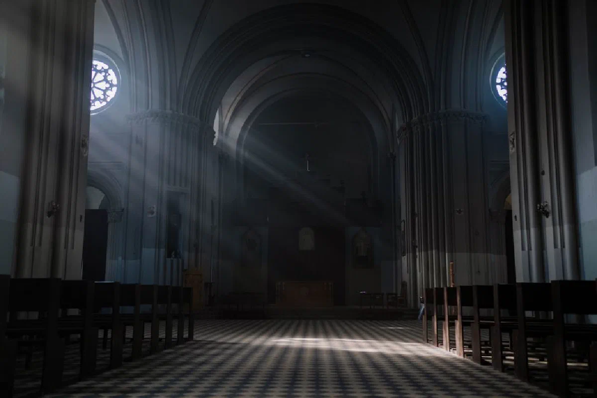 Gothic cathedral interior with sunrays illuminating the altar and arches, creating a peaceful ambiance.
