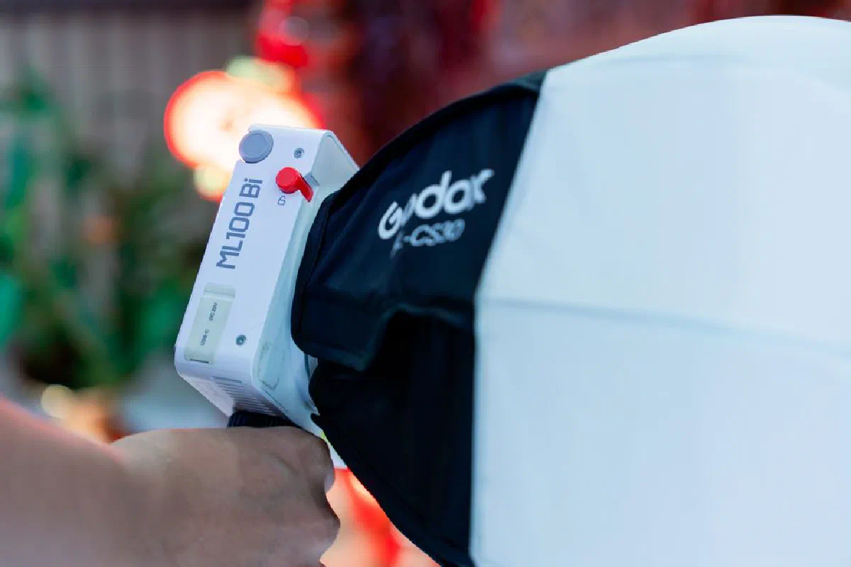Detailed view of a Godox LED portable light with a hand holding it, ideal for indoor studio photography.