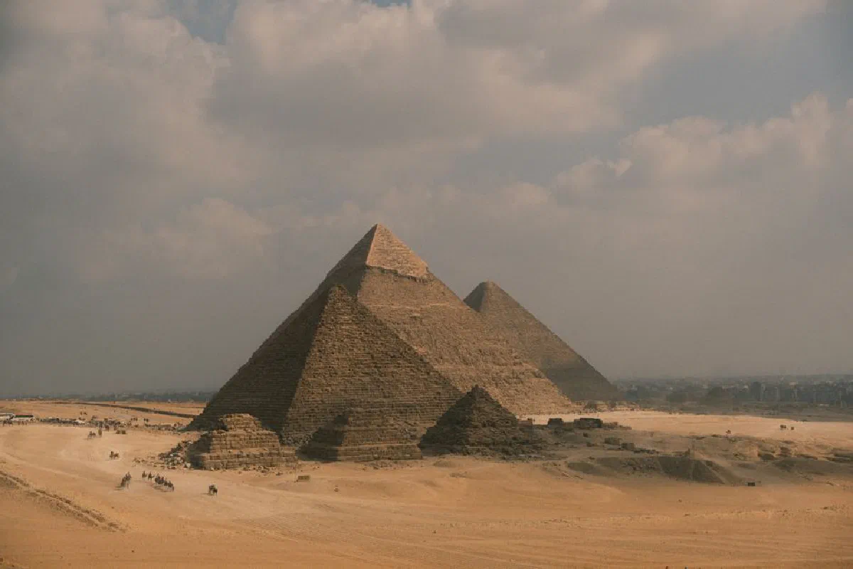 A stunning view of the Pyramids of Giza set against a picturesque sky in the Egyptian desert.