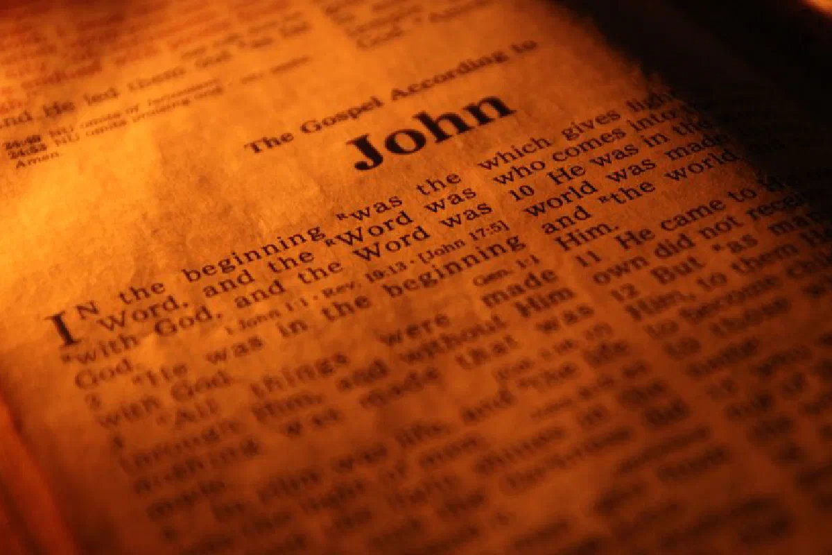 Focused close-up of the Bible's Gospel of John, highlighting sacred scriptures under warm light.