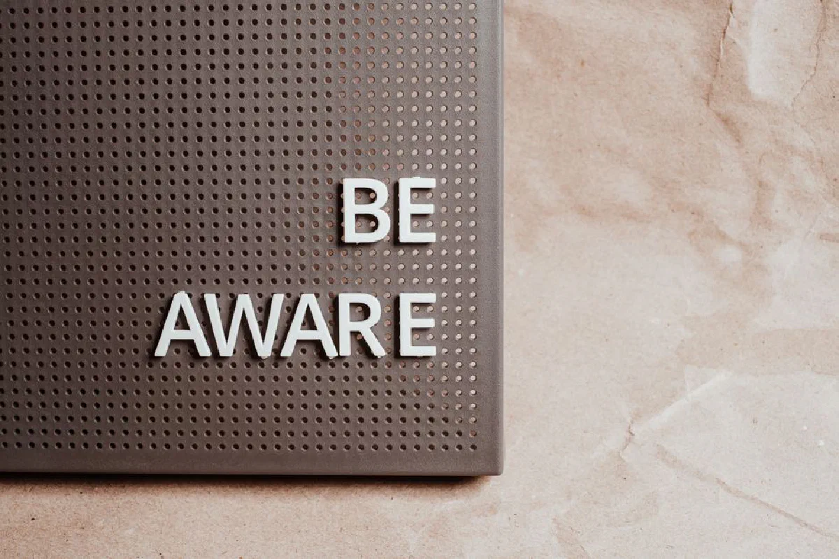 Be Aware wording on brown textured perforated surface, offering copyspace.