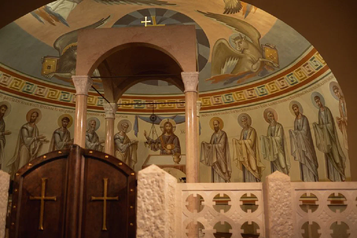 A detailed view of an Orthodox church interior showcasing religious frescoes and architecture.