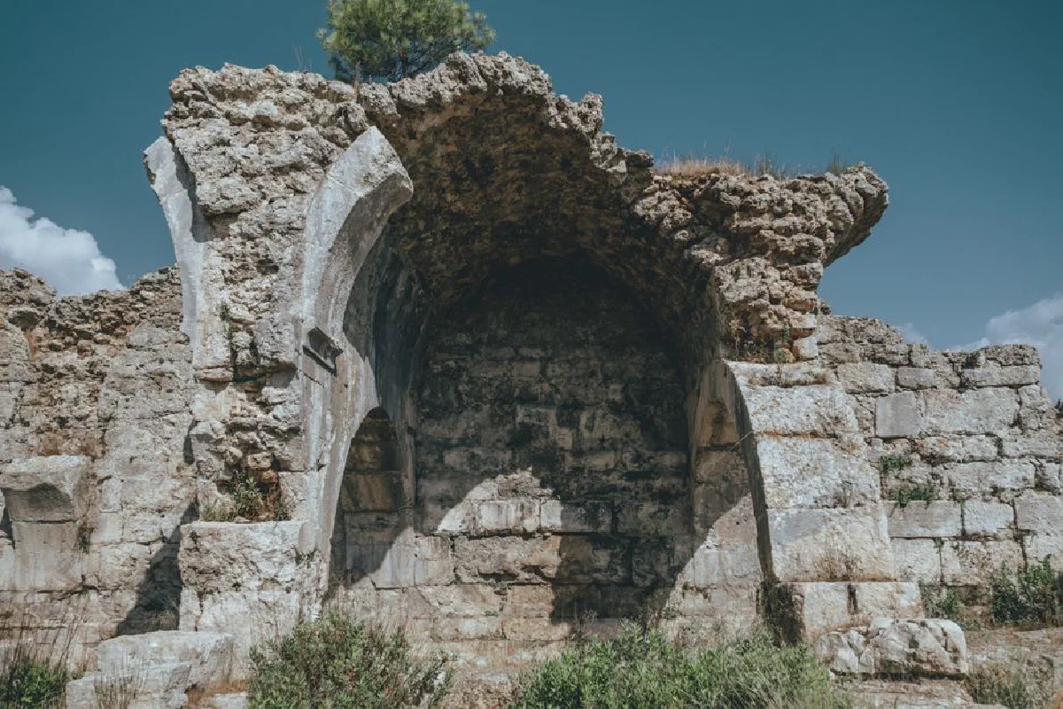 Explore the timeless beauty of ancient stone ruins with archways under a clear blue sky.