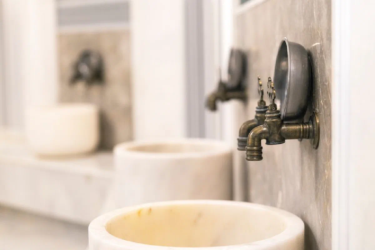 Close-up of vintage Turkish bath faucets with marble basins, showcasing traditional design.