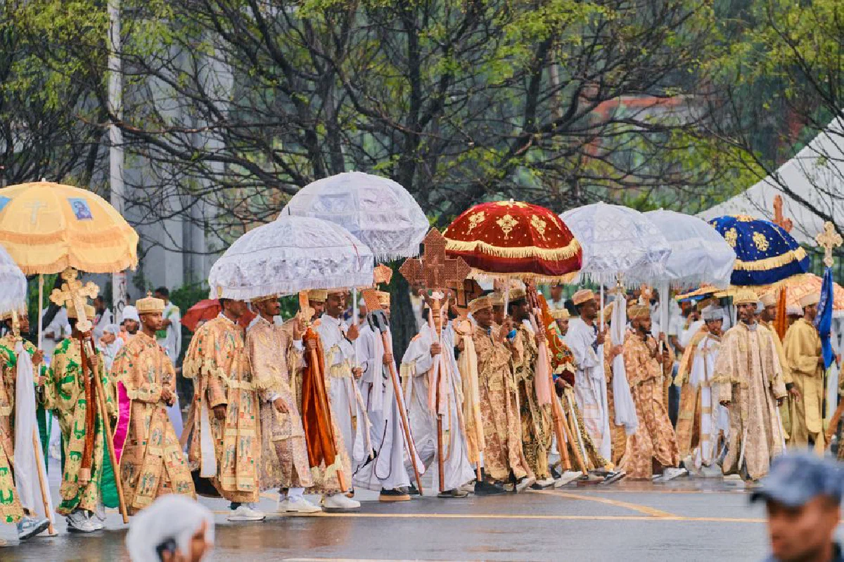 Vibrant Ethiopian religious procession with umbrellas in a ceremonial parade.