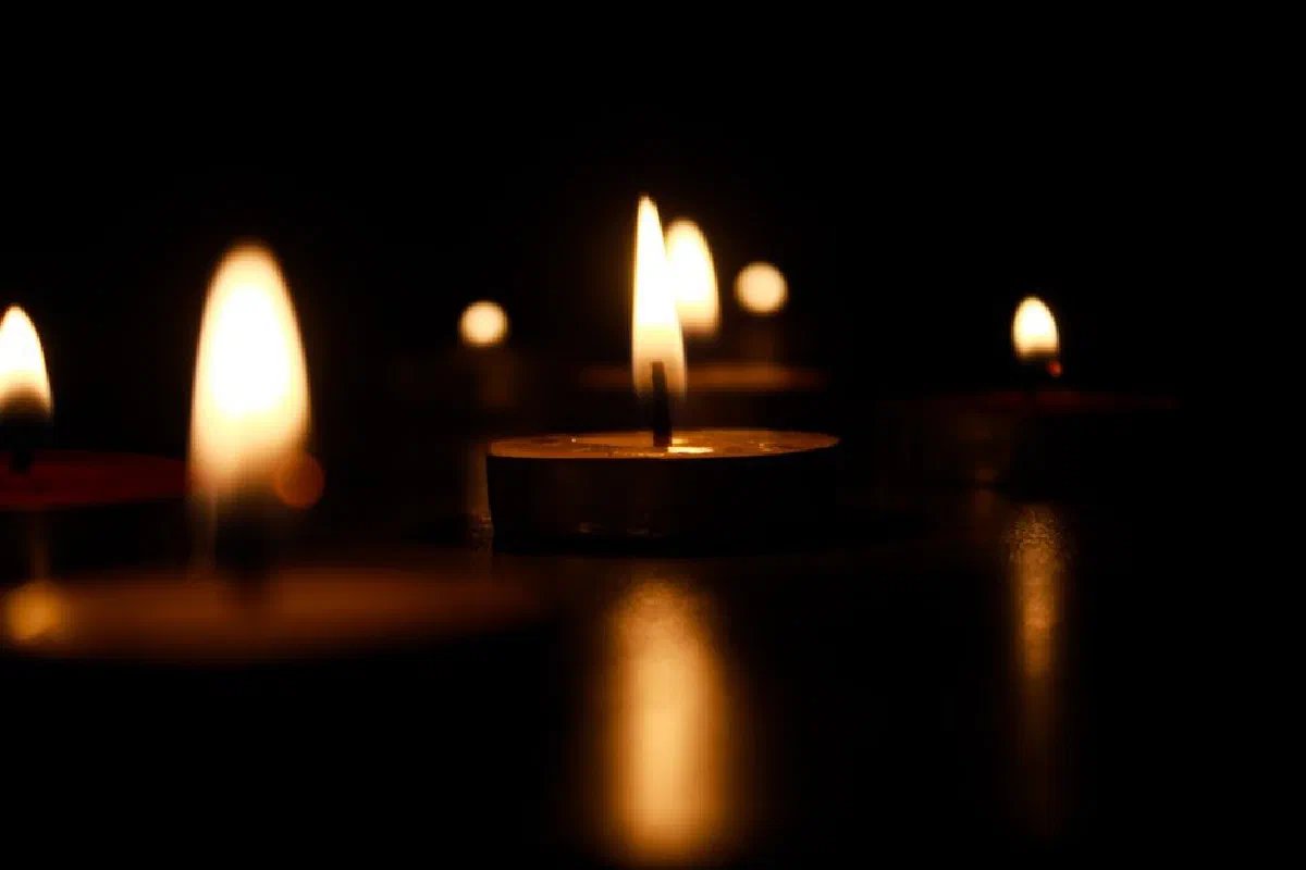 A serene close-up of lit candles casting warm glow in the dark, creating a peaceful ambiance.
