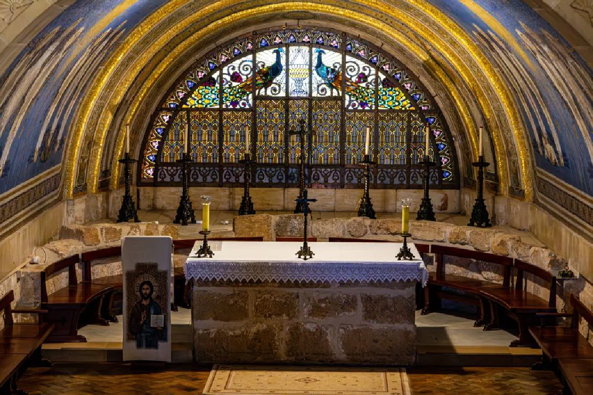 Beautiful chapel interior featuring ornate stained glass and altar with candles.