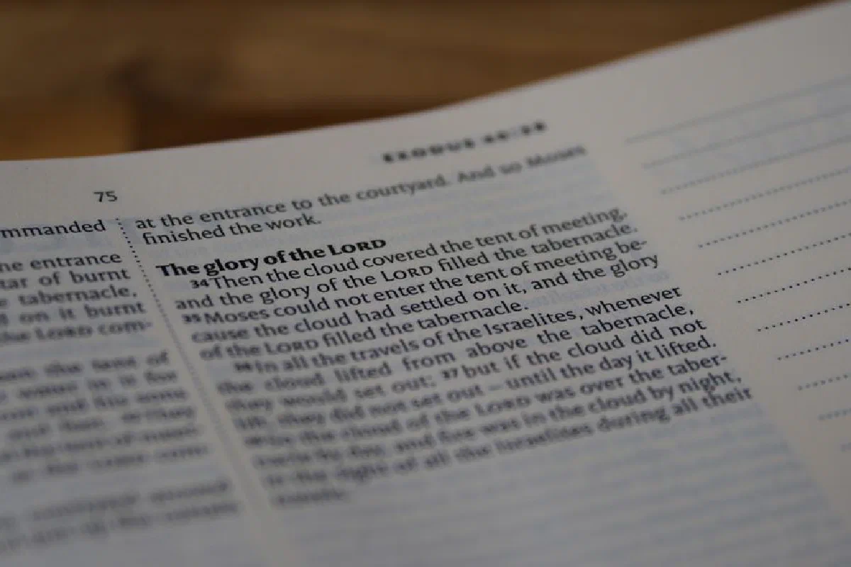 A focused close-up of a Bible page highlighting Exodus 40:34, depicting profound religious themes.