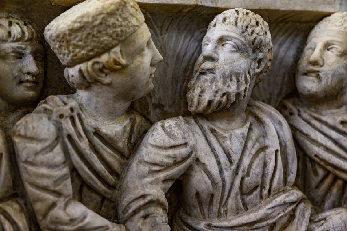 Close-up view of an intricately carved marble relief sculpture featuring bearded figures in the Vatican Museum.