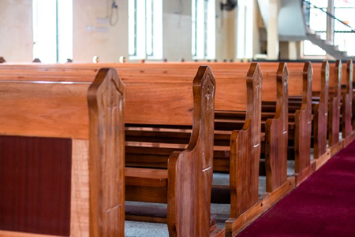 Elegant wooden church pews line an empty church in Ghana, creating a serene and sacred atmosphere.