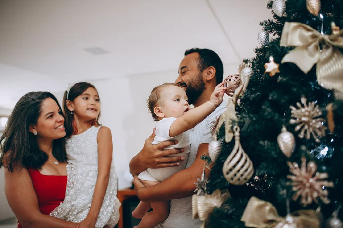 Joyful family bonding while decorating a Christmas tree at home.