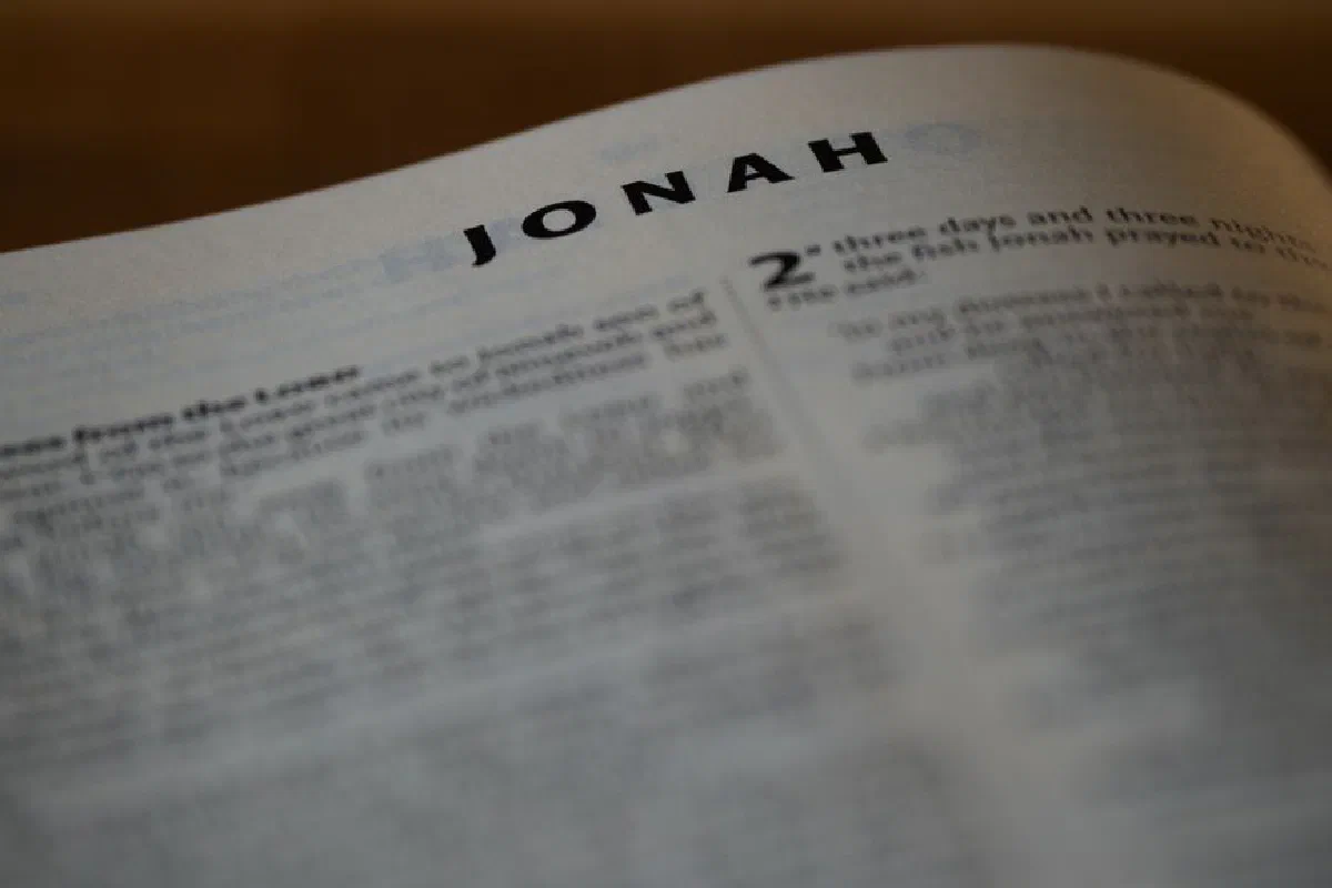 Blurred Bible page focusing on the Book of Jonah with visible text.