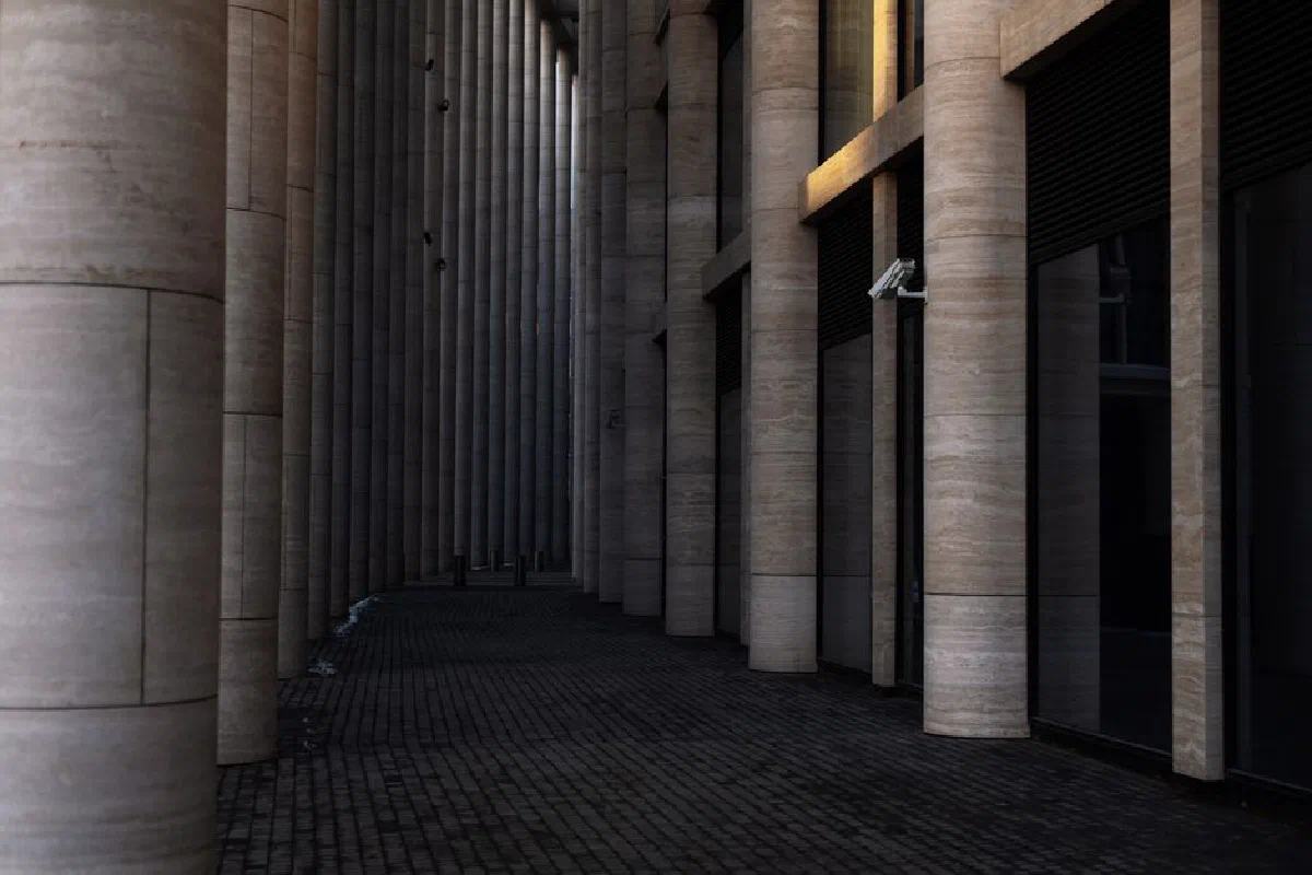 Contemporary colonnade corridor with tall columns and dramatic lighting effects.