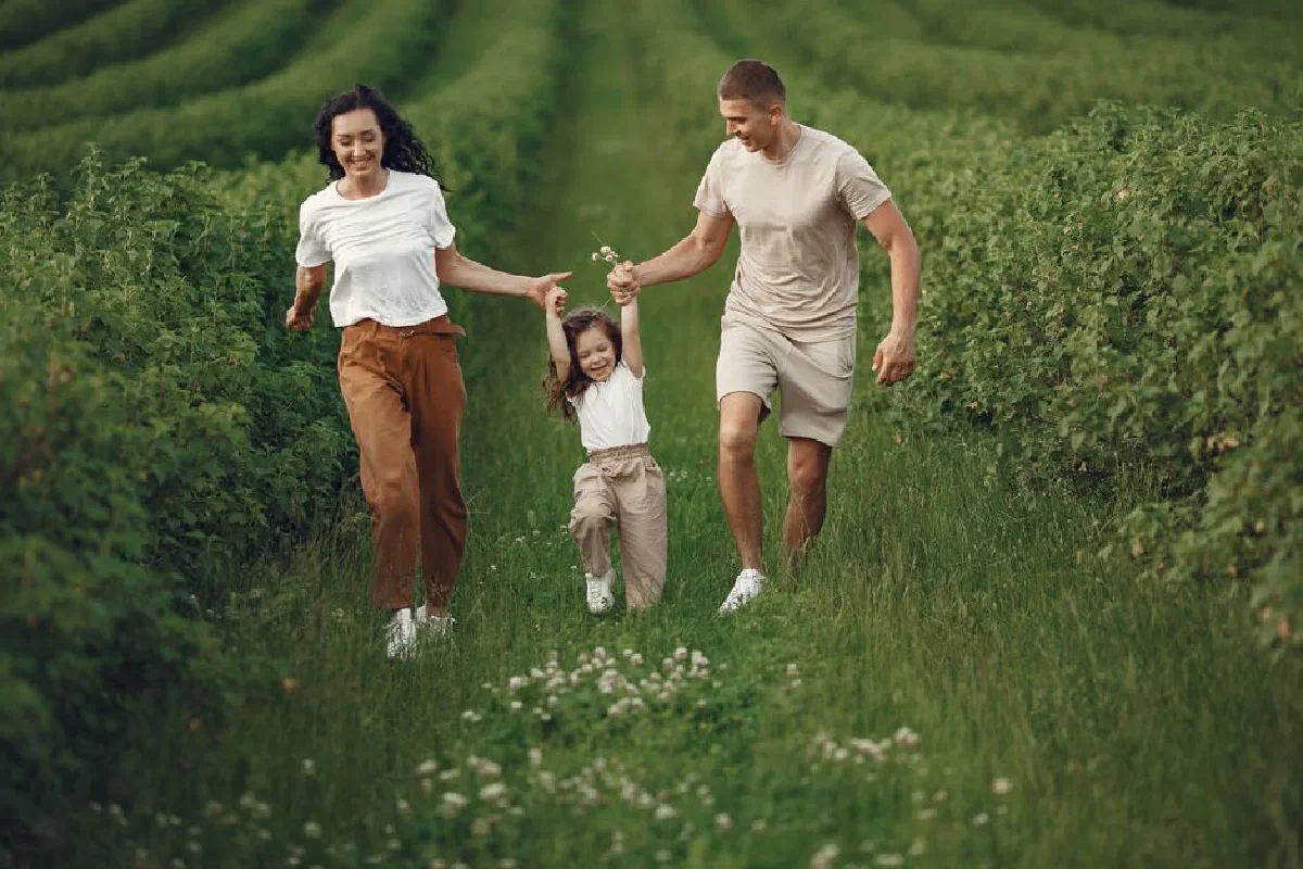 Joyful family enjoying a fun day outdoors in a green field, epitomizing togetherness and happiness.