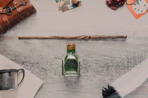 A mystical flat lay featuring a wand, potion bottle, and magical accessories.