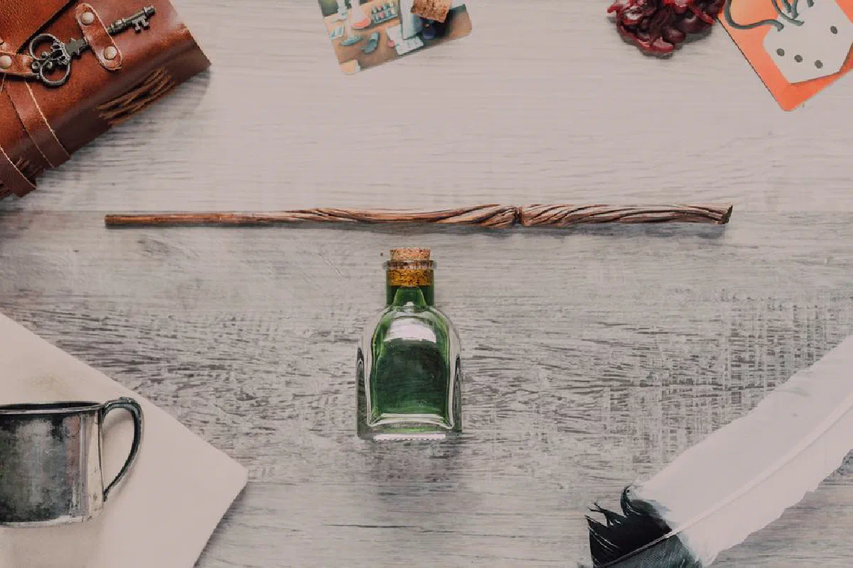 A mystical flat lay featuring a wand, potion bottle, and magical accessories.