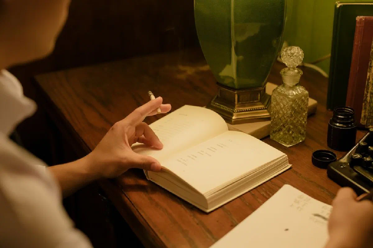 A serene indoor scene featuring a writer's desk with a vintage lamp, book, and ink bottle.