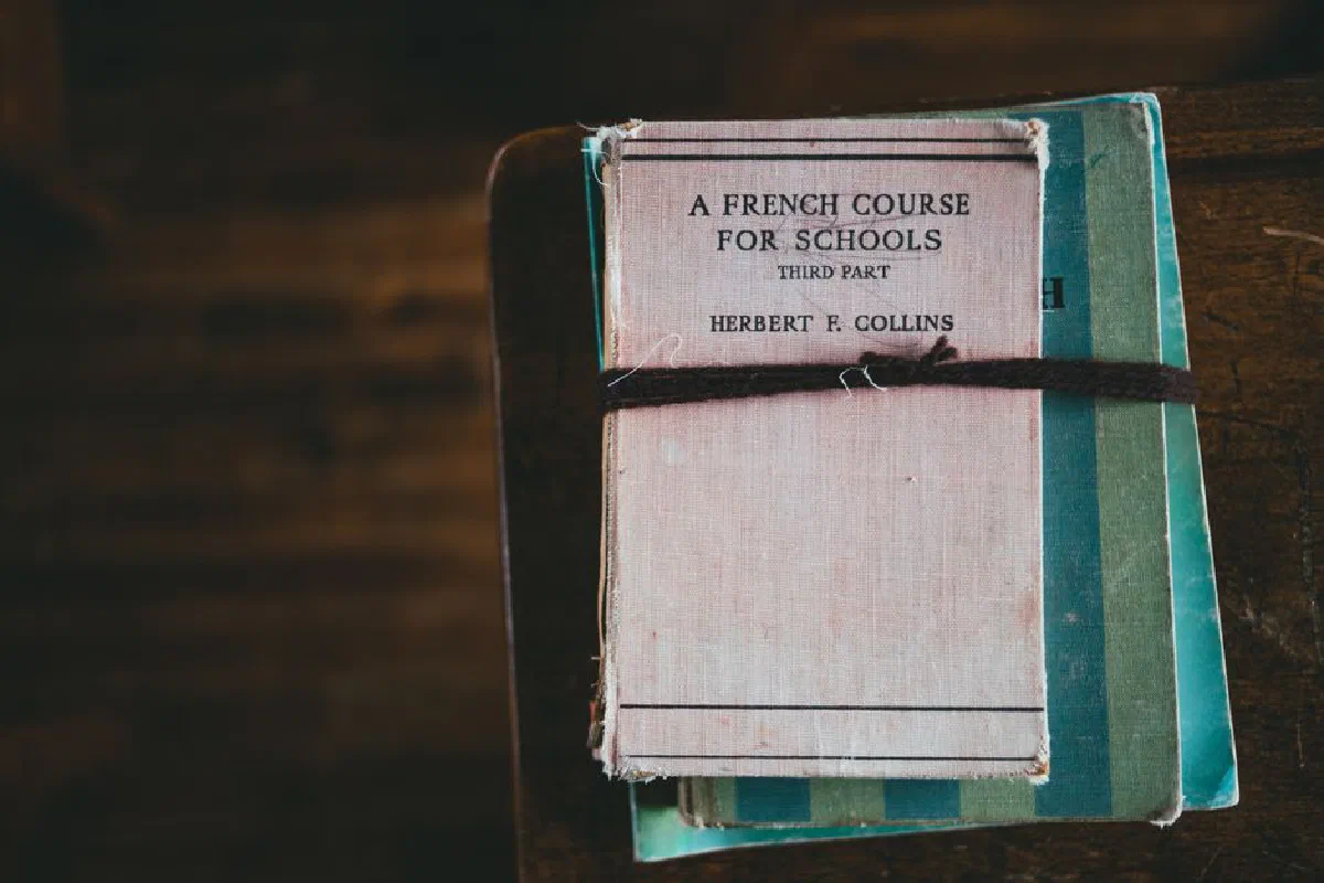A vintage French language coursebook tied with string, evokes educational nostalgia.