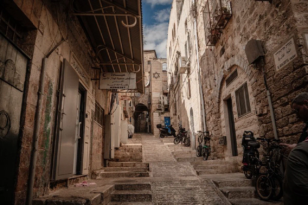A scenic view of a stone alley in Jerusalem's Old City, showcasing historic architecture and cultural ambiance.