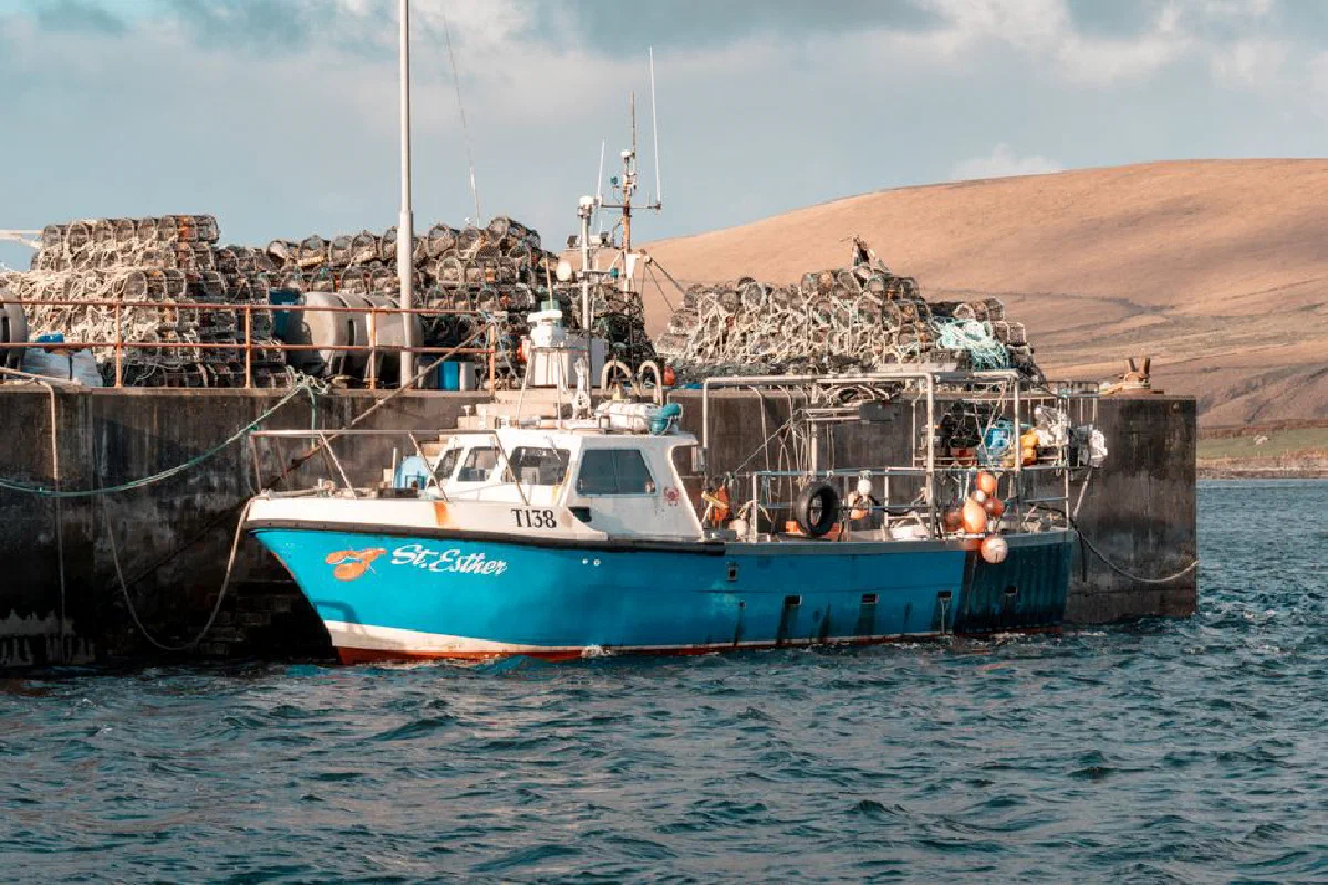 A vibrant fishing boat docked at an Irish fishing port with rugged landscapes.