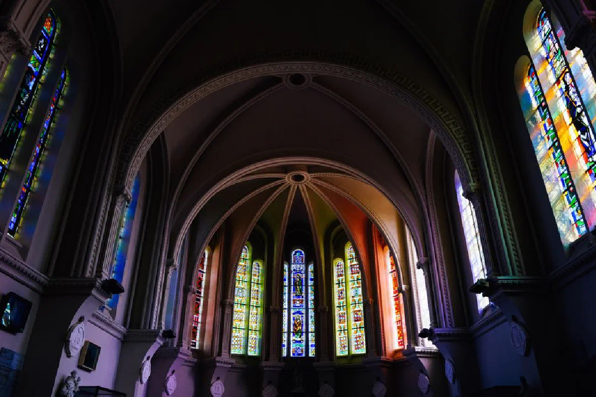 Stunning gothic cathedral interior featuring ornate stained glass windows and arched ceilings.