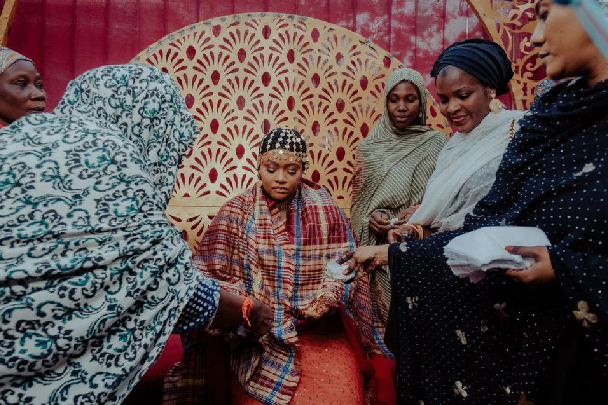 A group of African women in traditional attire participating in a cultural ceremony.
