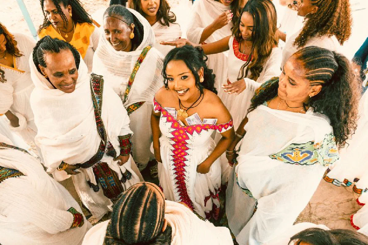 A group of Ethiopian women joyfully celebrating in colorful traditional dresses, showcasing cultural heritage.
