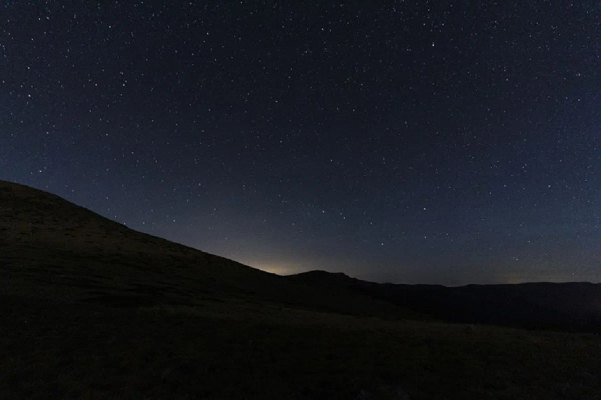 Explore the breathtaking view of a starry night sky over the mountains in Madrid, Spain.