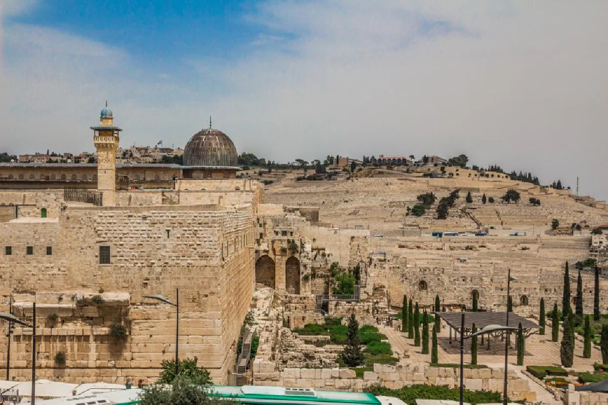 View of ancient Islamic architecture in Jerusalem with stone walls and domes under a clear sky.