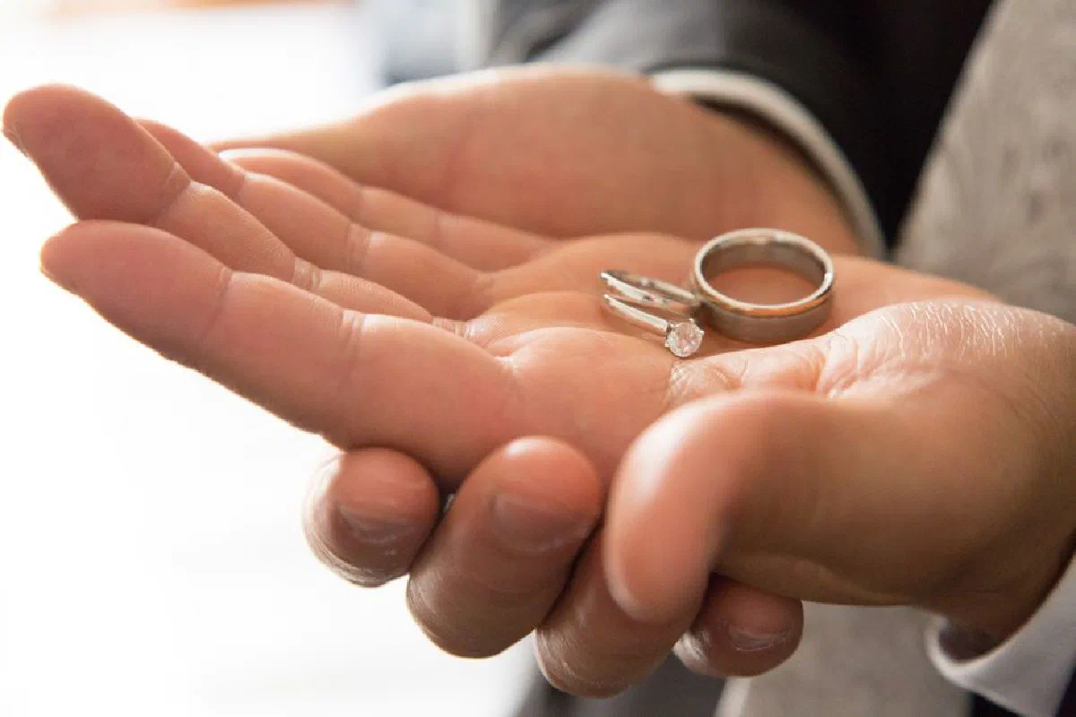Elegant close-up of hands holding wedding rings symbolizing love and commitment.