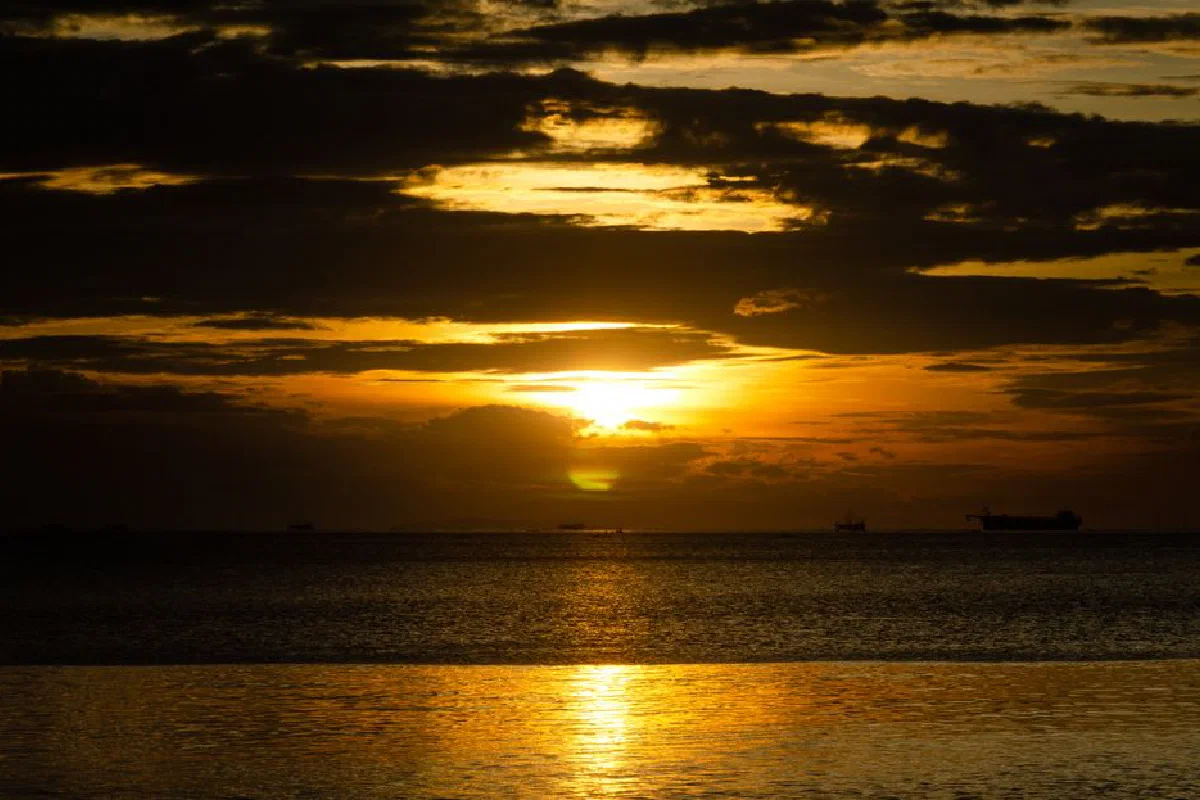 Breathtaking sunset view over Manila Bay in Pasay, Philippines, with dramatic clouds and ocean.