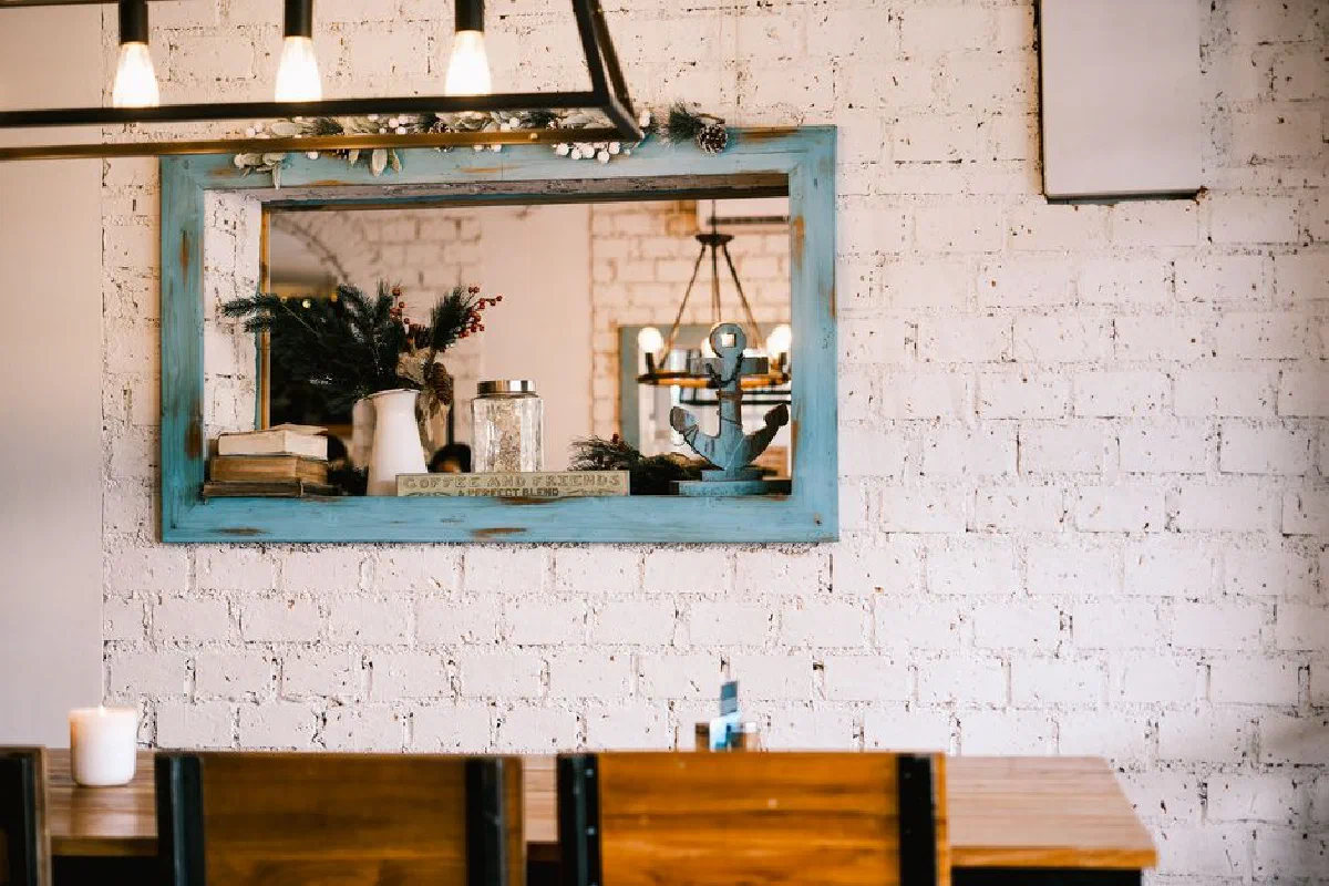 Warm rustic interior with wooden decor and mirror reflecting a cozy ambiance.