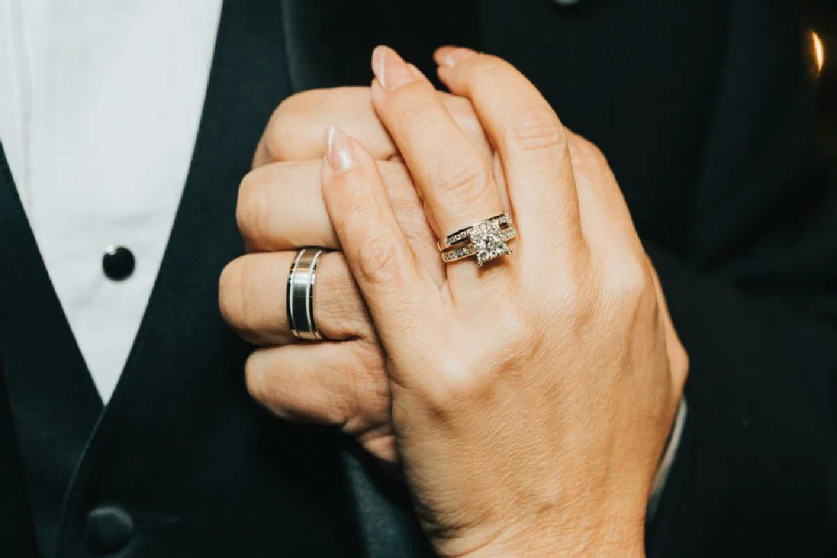 A romantic close-up of holding hands showcasing elegant wedding rings, symbolizing love and unity.