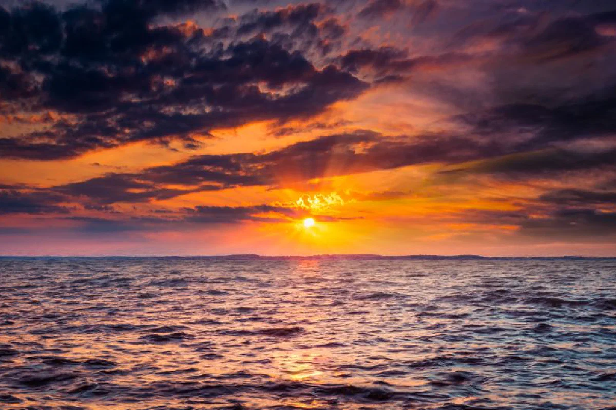 Beautiful sunset over the ocean with dramatic clouds and colorful sky.