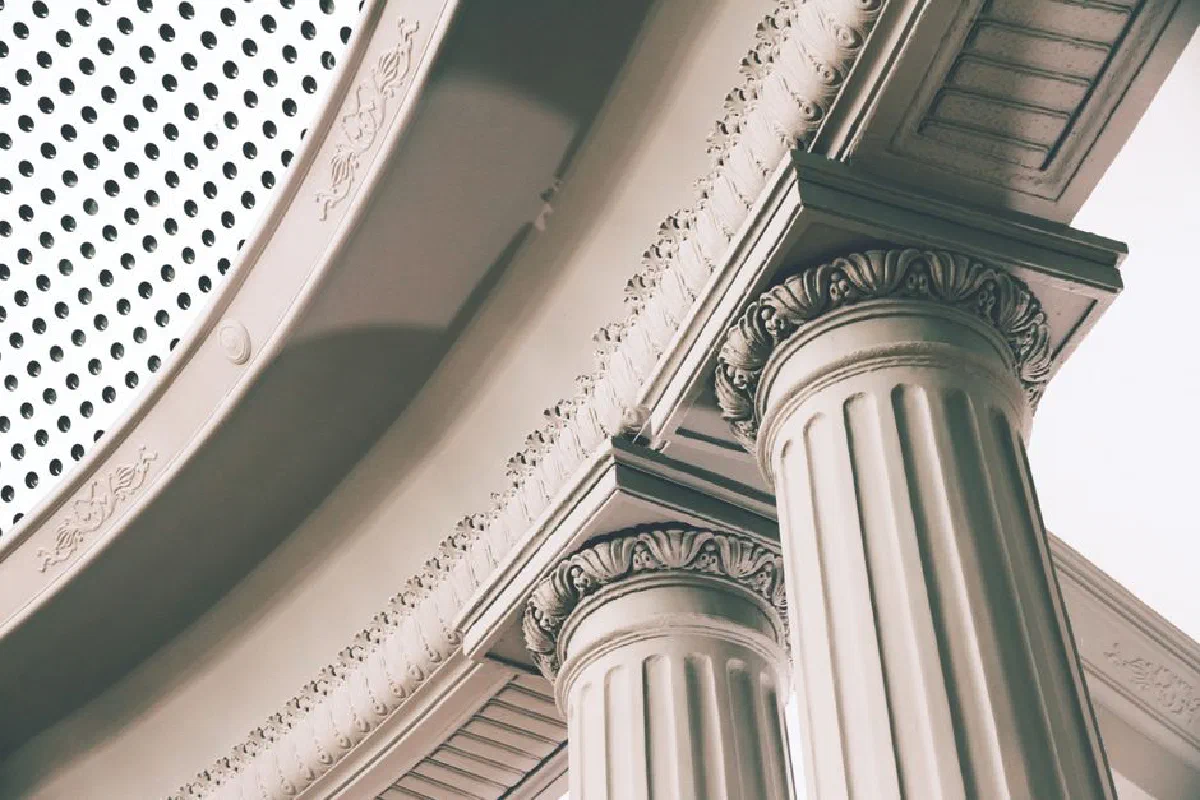 Detail of neoclassical columns with intricate carvings in an outdoor setting.