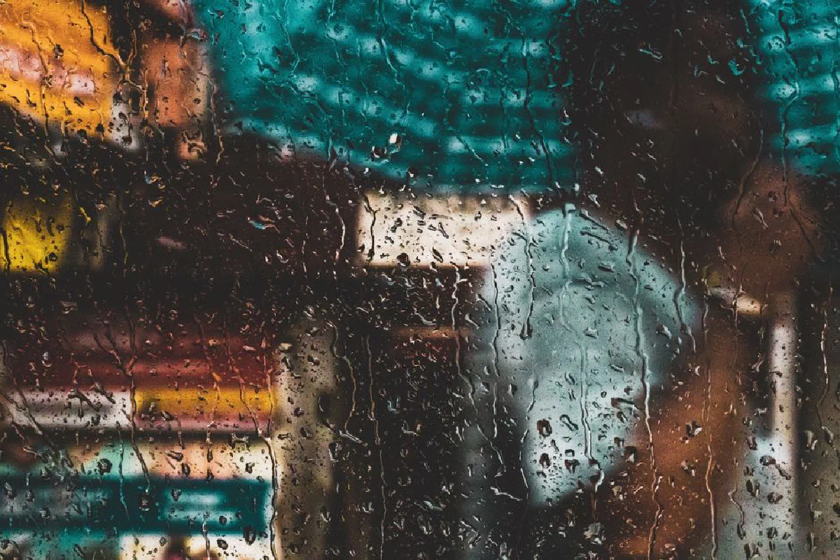 Blurred view through a rain-soaked window capturing the vibrant essence of Kolkata's streets.