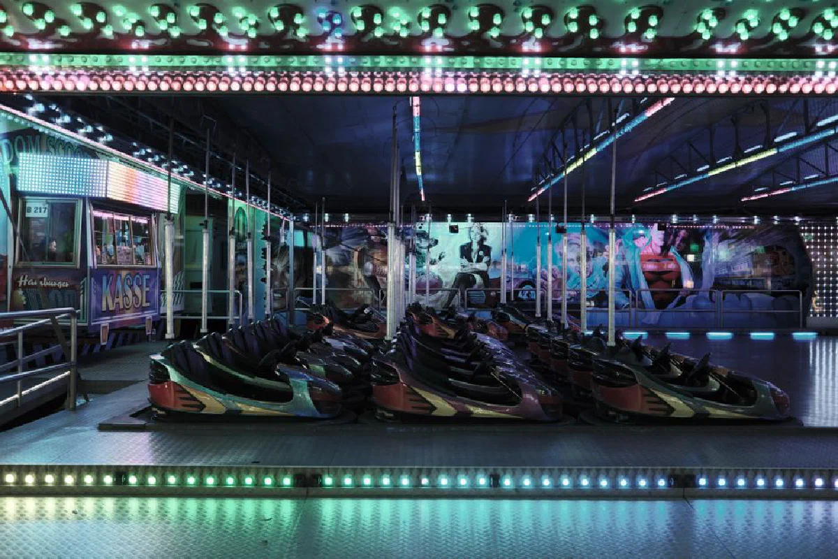 A vibrant and colorful bumper car ride at a fair in Hamburg, Germany, illuminated with bright lights and vibrant hues.