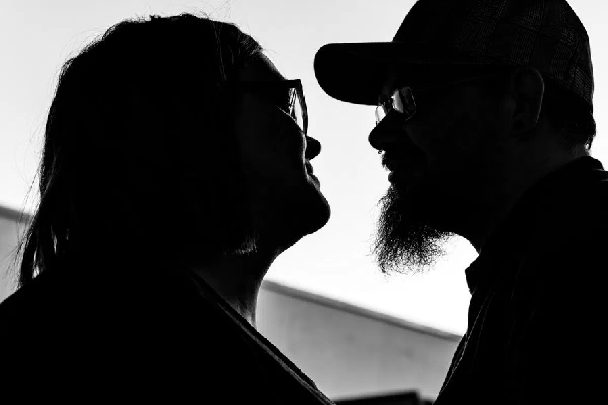 Silhouette of a couple facing each other, evoking romance and connection in a soft twilight setting.