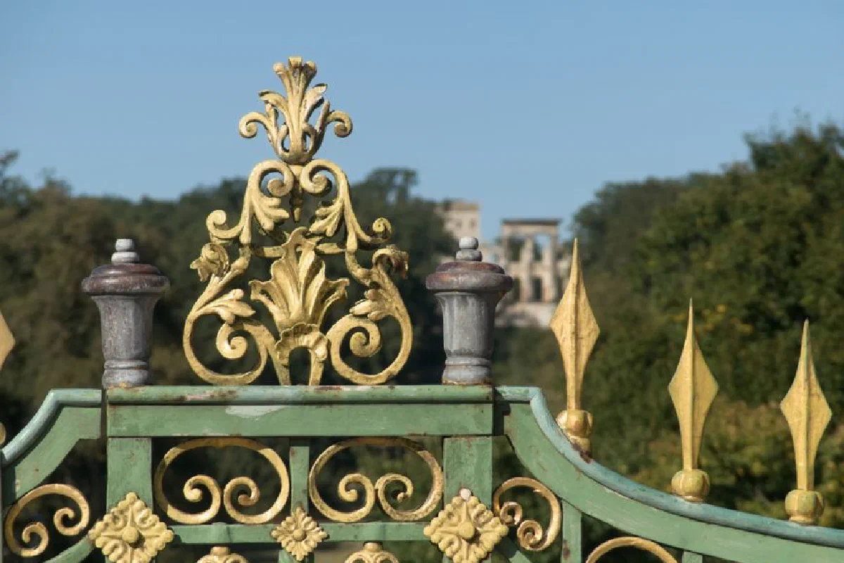Close-up of an ornate green and gold gate at Park Sanssouci in Potsdam, Germany.