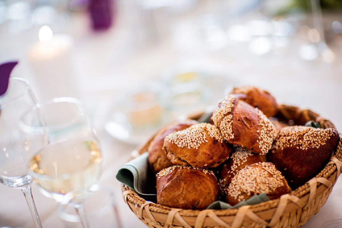 Delicious sesame seed rolls served in a wicker basket, perfect for a dining setting.
