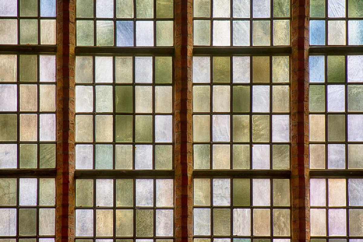 Close-up view of vintage stained glass windows in a church, showcasing intricate patterns.