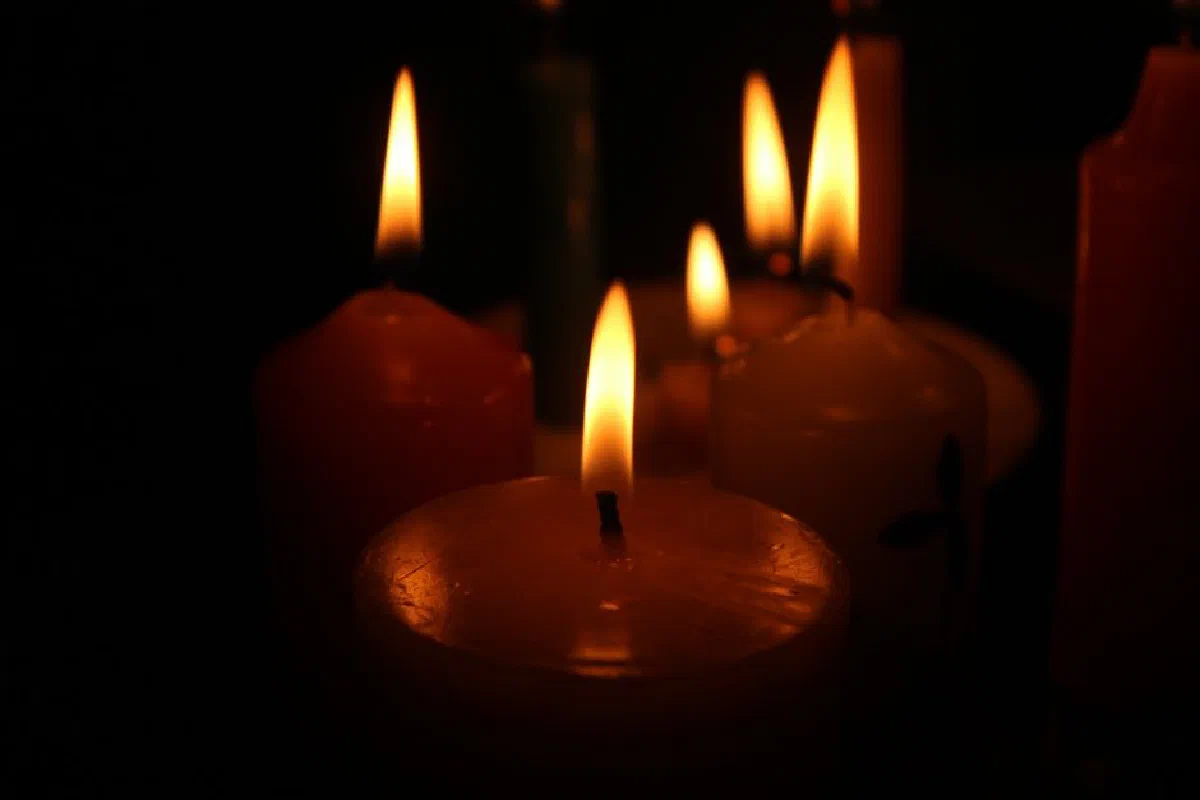 Multiple candles creating a warm and peaceful atmosphere in low light.