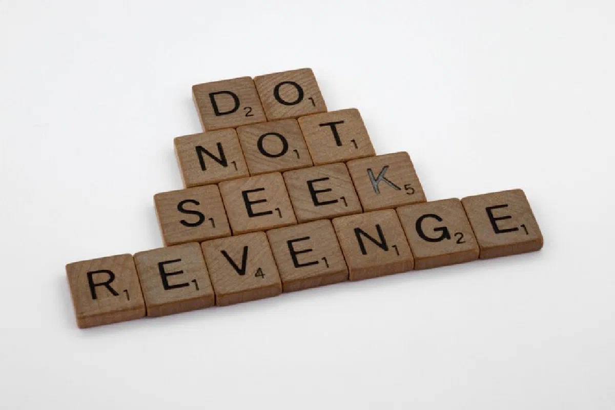 Wooden tiles arranged to spell an inspiring message about avoiding revenge.