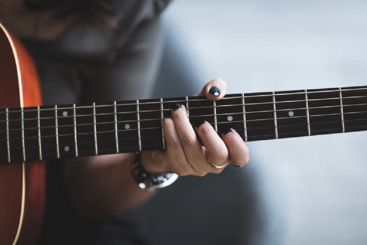 A musician's hand skillfully playing a guitar chord in a close-up shot.