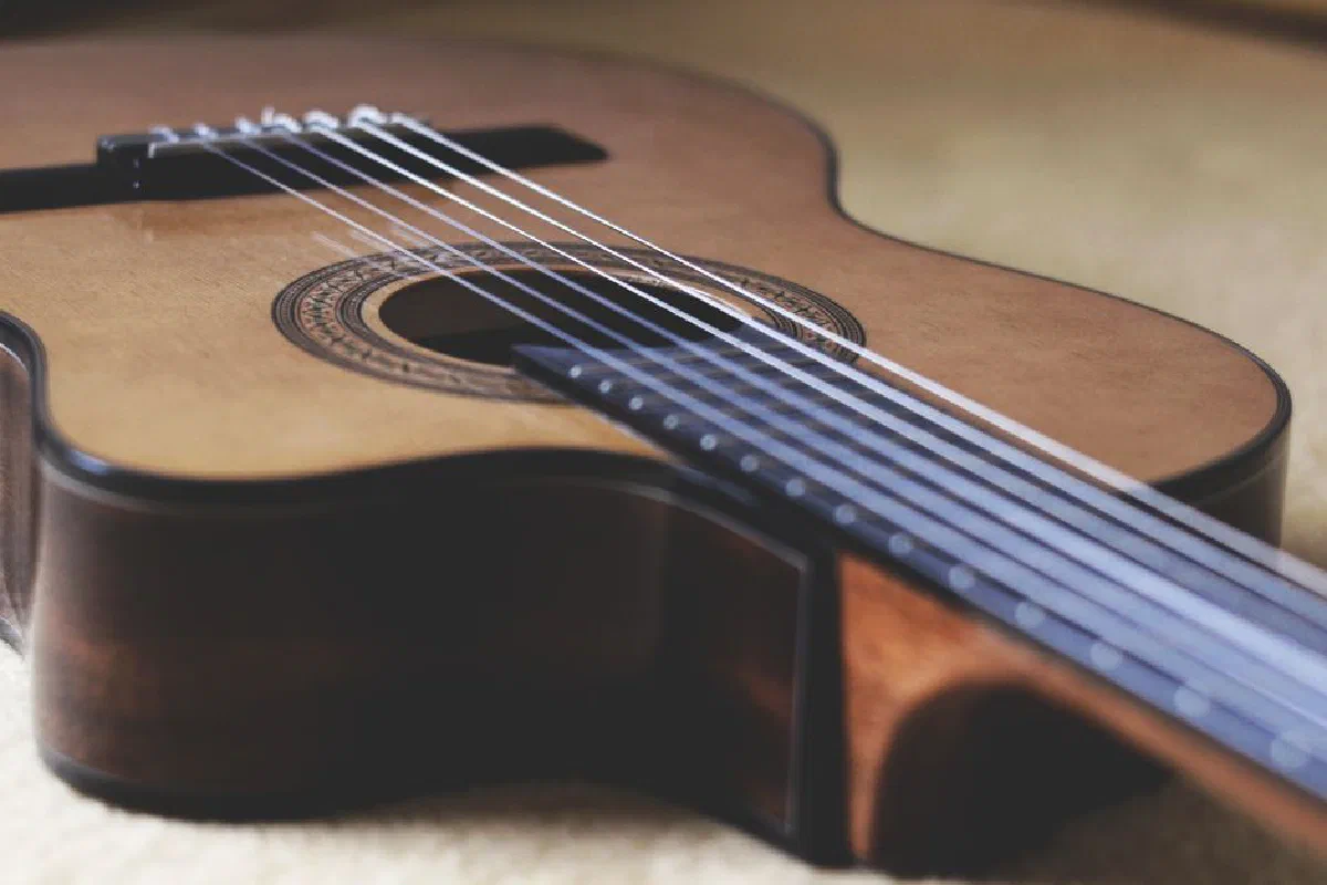 A detailed close-up of a classical guitar highlighting its strings and wooden body.